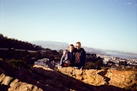 a man and woman standing on top of a rocky hill