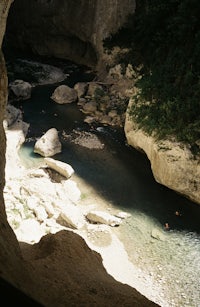 a man is swimming in a river in a cave