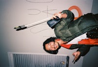 a man in a green jacket holding a bat
