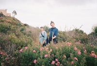 two people standing in a field of flowers