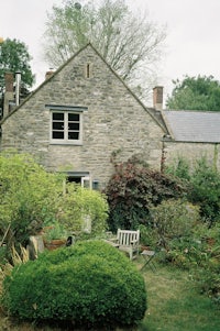a stone house with a bench in front of it