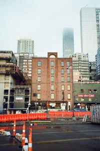 a construction site with orange cones in the middle of a street