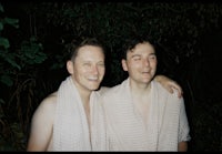two men in bathrobes standing next to each other