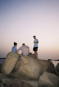 a group of people sitting on a large rock