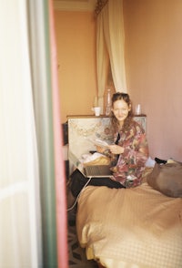 a woman sitting on a bed reading a book