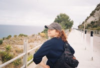 a woman wearing a hat and carrying a backpack