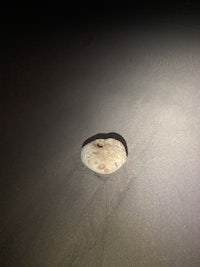 a rock in the sand with a light shining on it