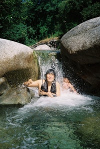 a man in a wetsuit laying in a river