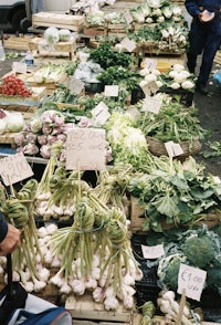 a man standing in front of a display of vegetables