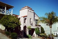 a pink building with a palm tree in front of it