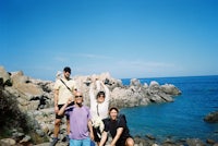 a group of people posing for a picture near the ocean