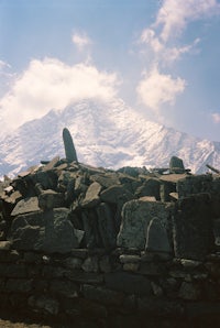 a pile of rocks in front of a snowy mountain