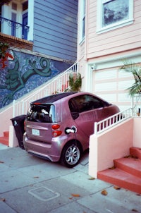 a pink car parked in front of a house
