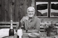 a man sitting at a table with a bottle of wine