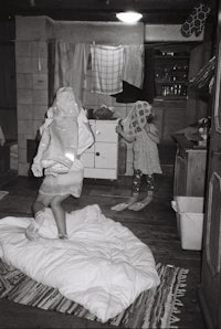 a woman is standing on a bed in a kitchen