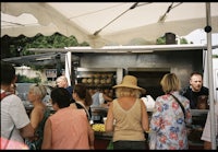 a group of people standing in line at a food truck
