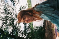 a woman laying on a blanket next to a body of water