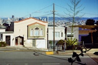 a street with a lot of houses and a city in the background