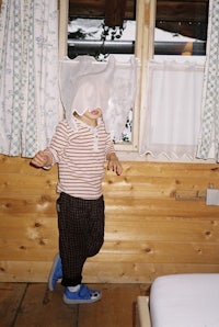 a child wearing a mask in front of a window