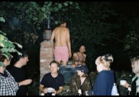 a group of people standing around a fire pit
